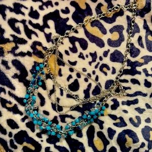 Multi layered silver necklace with a With teal and clear stones